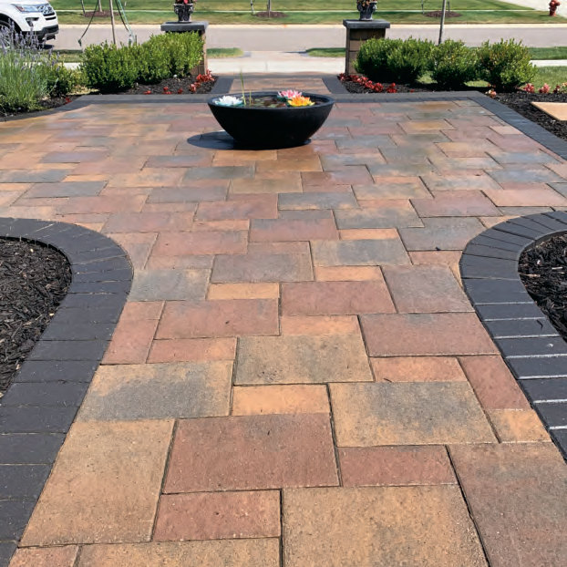 Pavers Brick walkway under construction beside a stone building, with gravel and soil base visible.